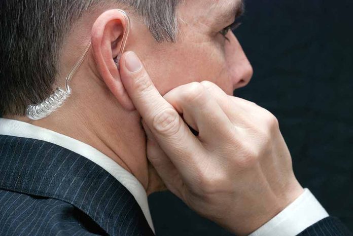 Man wearing an earpiece, touching his ear.