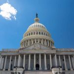 U.S. Capitol building against a clear blue sky.