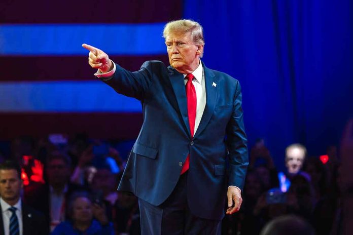 Man in blue suit pointing, audience in background.