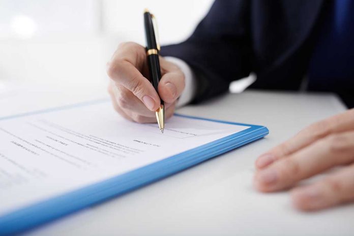 Person signing a document with a pen.