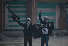 People holding and waving a black flag.