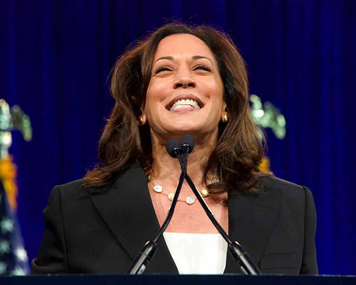 Woman smiling behind a podium with microphones.