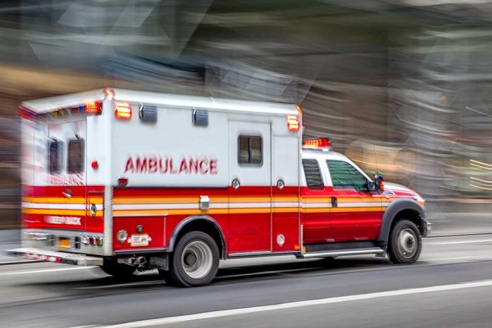 Red and white ambulance driving on street.