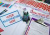 Voter registration table with forms, pens, and information.