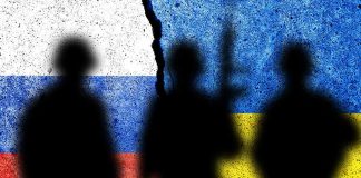 Silhouettes against split Russian and Ukrainian flags.