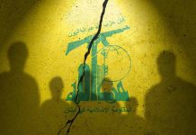 Hezbollah flag with shadows of people and a crack.