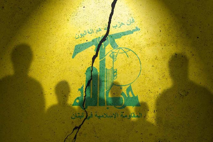 Hezbollah flag with shadows of people and a crack.