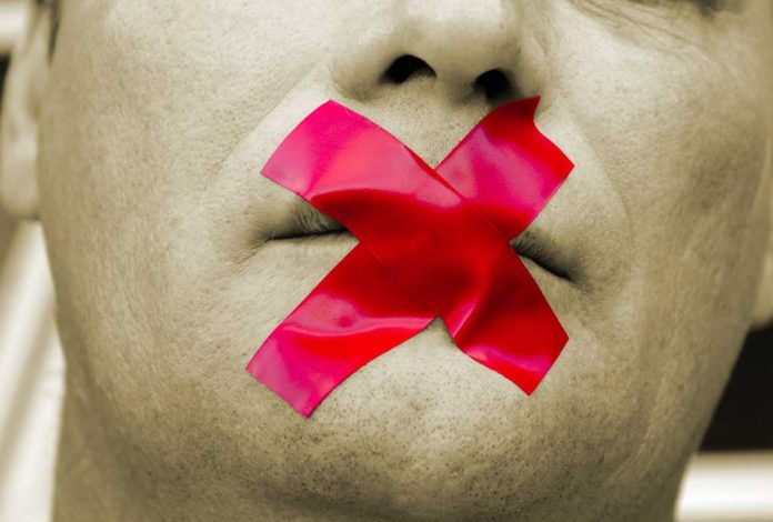 Man with red tape over mouth.