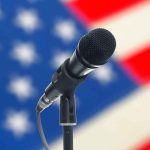 Microphone with American flag in the background.