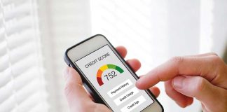 Hand holding phone showing credit score app interface
