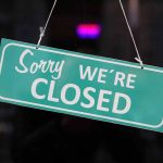 Green "Sorry, We're Closed" sign hanging in window.