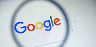 Google logo viewed through a magnifying glass.