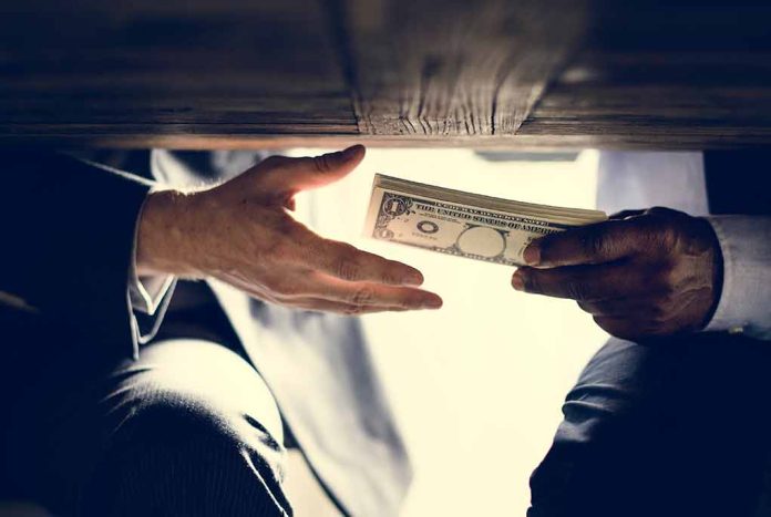 Hands exchanging money under a table.