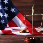 Scales of justice and American flag background.