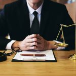 Person in suit with gavel and scales of justice