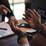 Handcuffed person in police station during interrogation