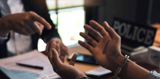 Handcuffed person in police station during interrogation