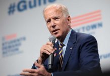 Man in suit speaking into microphone at event