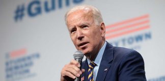 Man in suit speaking into microphone at event