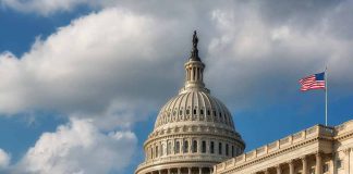 US Capitol Building with American flags and clouds