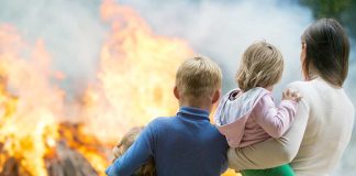 People watching large outdoor fire together