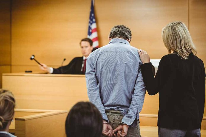 Man handcuffed in courtroom with supportive woman present