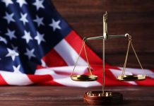 Scales of justice and American flag background.