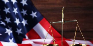 Scales of justice and American flag background.