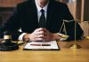 Person in suit with gavel and scales of justice