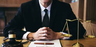 Person in suit with gavel and scales of justice