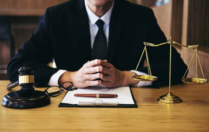 Person in suit with gavel and scales of justice