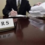 IRS sign on desk with person working