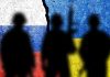 Silhouettes against Russian and Ukrainian flag background crack