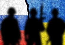 Silhouettes against Russian and Ukrainian flag background crack