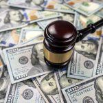 Gavel on pile of hundred dollar bills