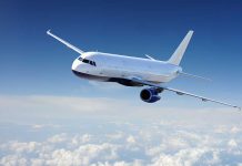 Airplane flying above fluffy white clouds sky