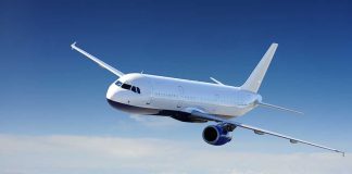 Airplane flying above the clouds in blue sky