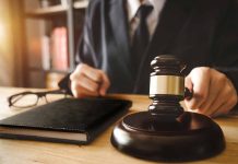 Gavel judges hand glasses and book on desk