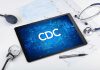 Tablet with CDC logo surrounded by medical equipment