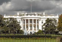 The White House with overcast sky and flag raised.