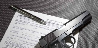 Gun, pen, and form on textured surface.