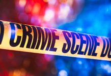 Yellow crime scene tape with blurred lights background