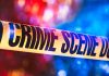 Yellow crime scene tape with blurred lights background