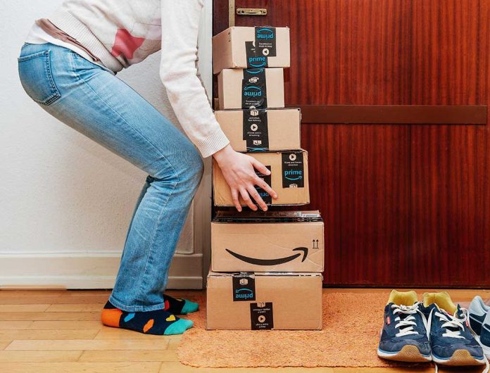 1126539725 featured image Person stacking Amazon boxes near door shoes nearby