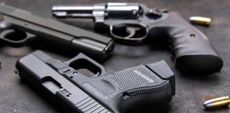 Handguns and bullets on a dark surface