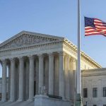 US flag flying outside a neoclassical government building