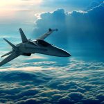 Jet flying above fluffy clouds at sunset