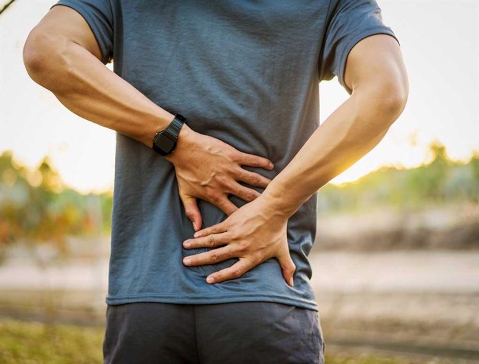 1020731773 featured image Person holding lower back in discomfort outdoors