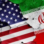 Cracked American and Iranian flags on concrete background