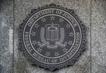 FBI seal on granite wall displaying department motto